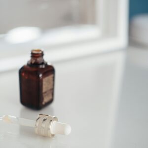 A serene scene with an essential oil dropper and brown bottle on a bright table.